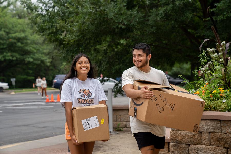 Doane senior Arturo Salinas helps his sister, 阿莉莎, move boxes into the residence hall during the university’s move-in day for first-year students. 